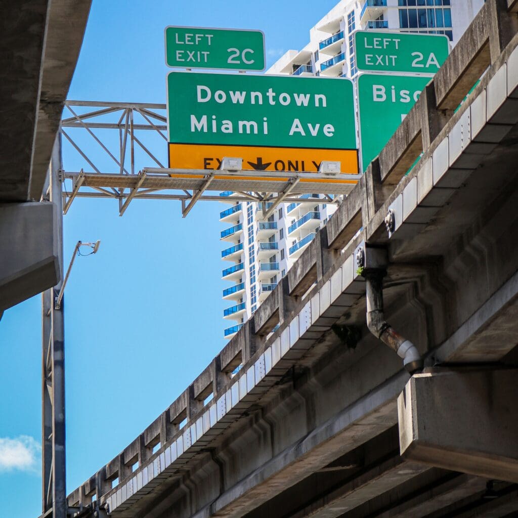 Elevated highway ramp beneath exit signs for Downtown and Miami Avenue in Miami, Florida